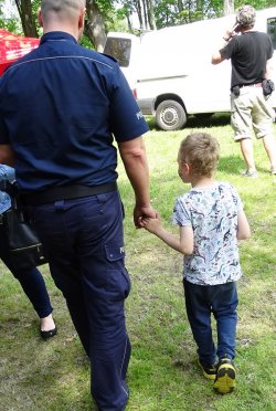 policjant idzie z dzieckiem za rączke