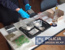Na zdjęciu policjant zabezpiecza znalezione narkotyki