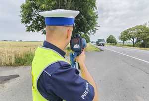 Policjant trzymiacy w ręku miernik prędkości