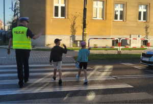 Policjant przy przejściu dla pieszych z dziećmi